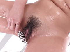 Japanese Nudes presents: Japanese teen in bikini oils up her hairy pussy